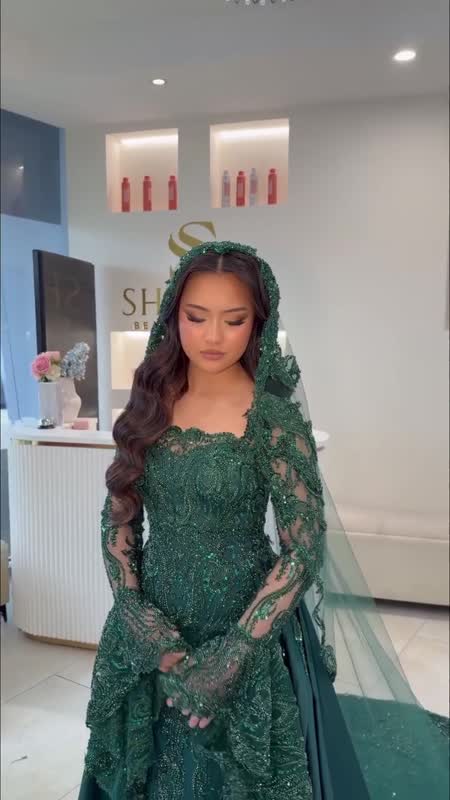 Horiah in an emerald gown, hair and makeup by the lounge